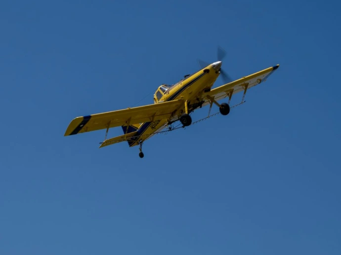 a yellow plane flying in the sky